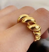 Gold geometric adjustable ring worn on a finger, showcasing a twisted spiral design, perfect for stylish accessorizing.