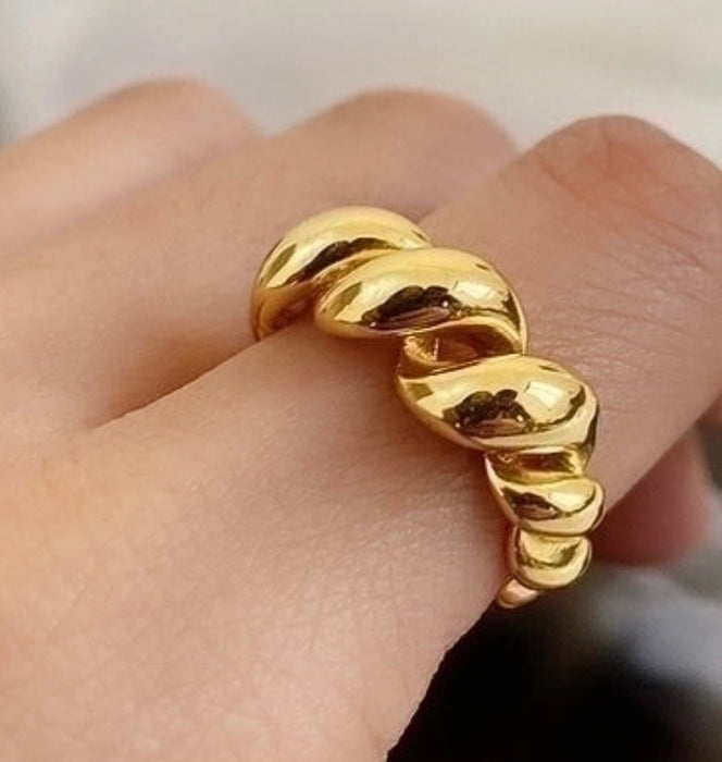Gold geometric adjustable ring worn on a finger, showcasing a twisted spiral design, perfect for stylish accessorizing.