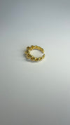 Twisted gold adjustable ring on a light background, perfect for stylish accessorizing.