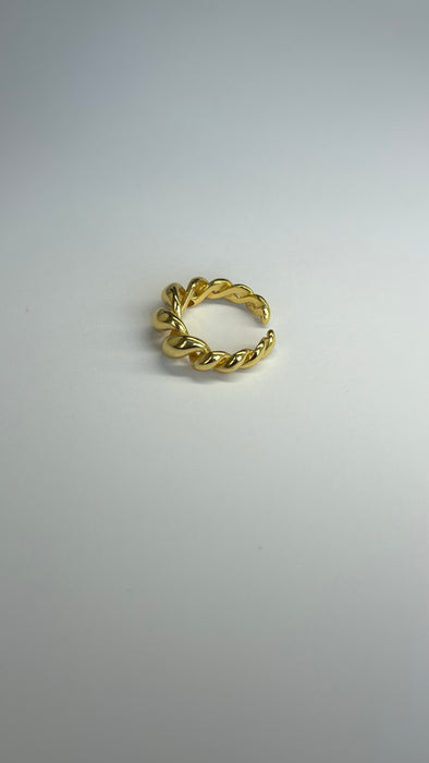 Twisted gold adjustable ring on a light background, perfect for stylish accessorizing.