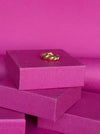 Geometric adjustable Mia ring in 925 sterling silver displayed atop vibrant pink gift boxes.