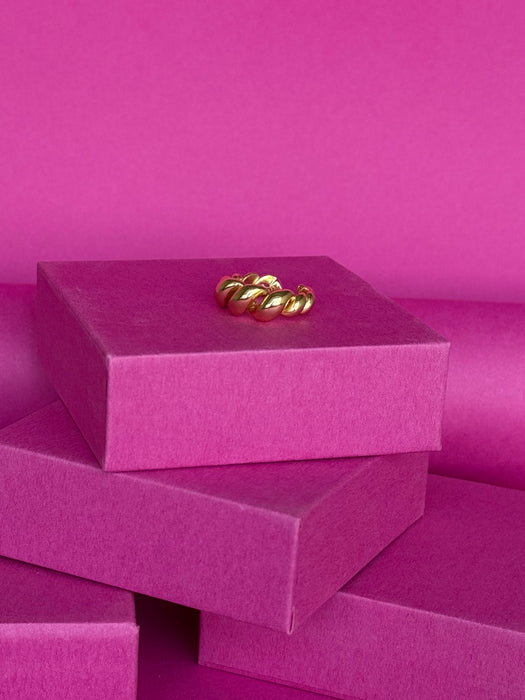 Geometric adjustable Mia ring in 925 sterling silver displayed atop vibrant pink gift boxes.