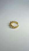 Gold twisted adjustable ring on a plain background, showcasing a modern and stylish design.