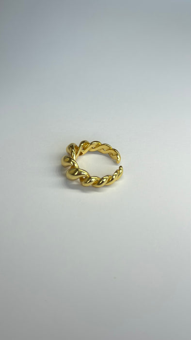Gold twisted adjustable ring on a plain background, showcasing a modern and stylish design.